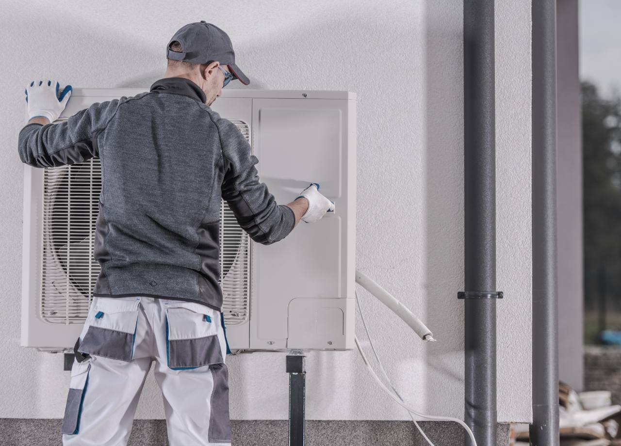 Mann beim Einbau der Heizung für eine Fertiggarage in Weiß