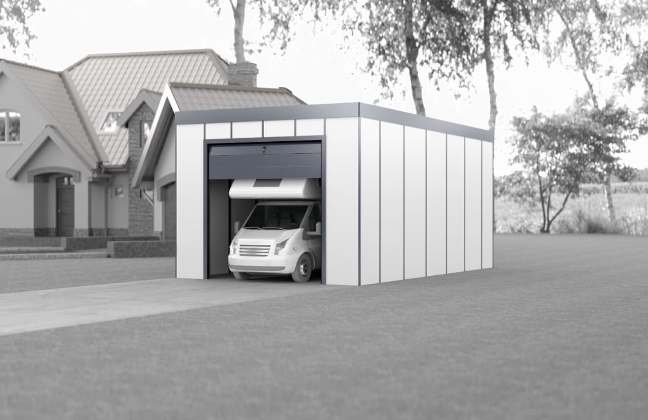 Weiß verputzte Fertigteil-Einzelgarage mit weißem Wohnmobil im Inneren und offenem Rolltor, die im Garten neben dem Haus auf Pflastersteinen steht
